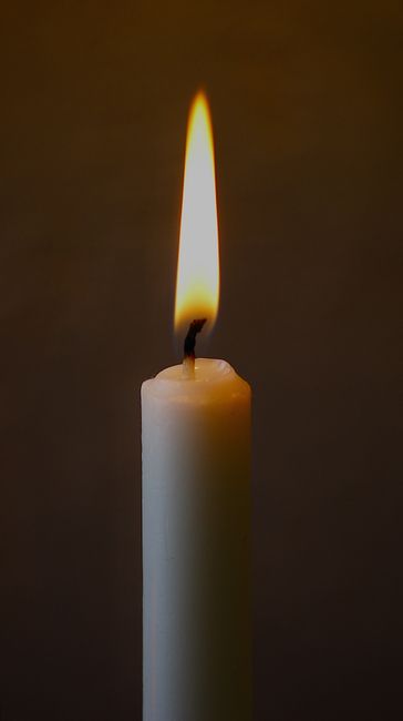 Vela blanca con llama brillante